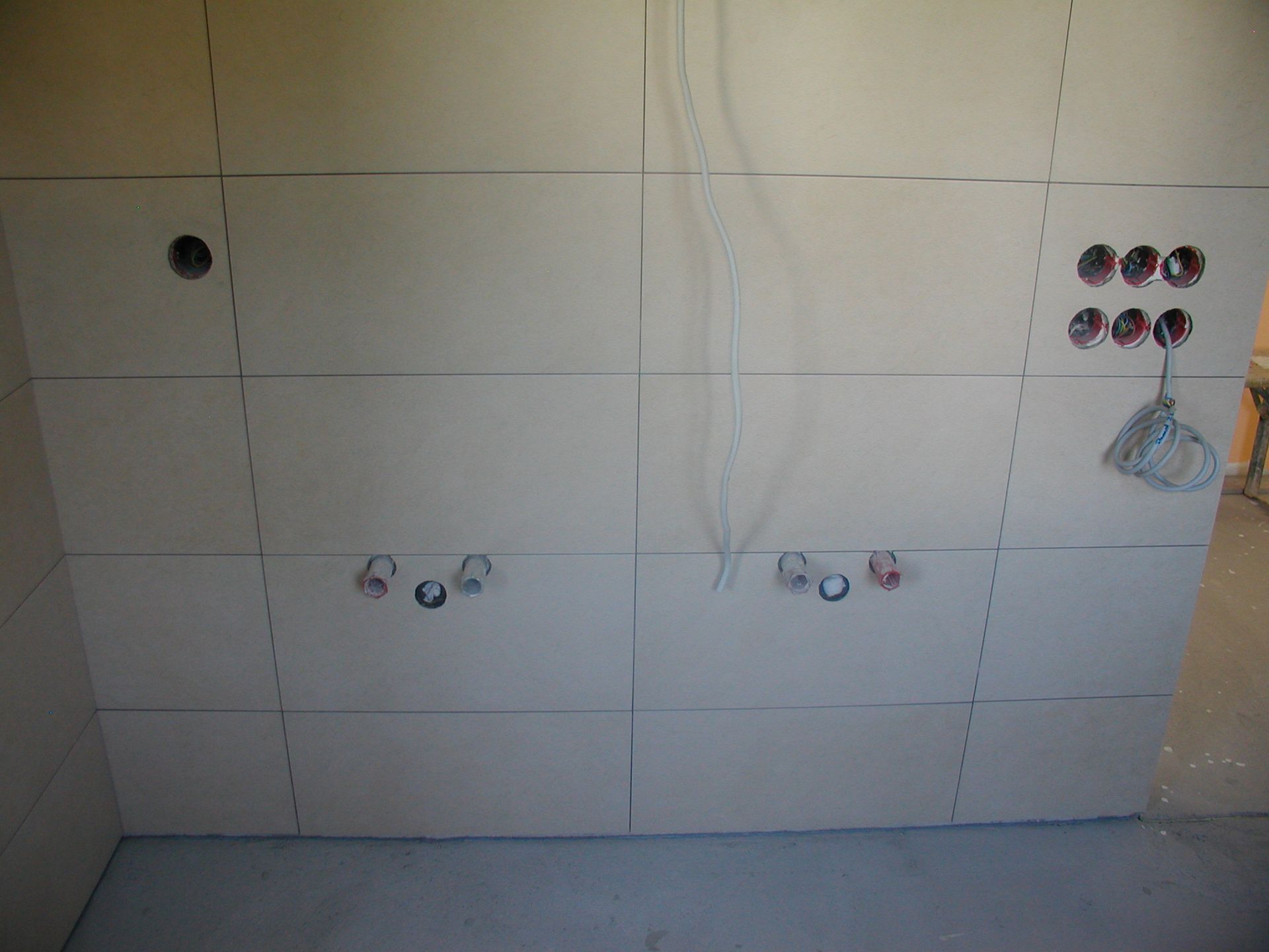 Verfliesste Wand mit vorbereiteten Anschlüssen